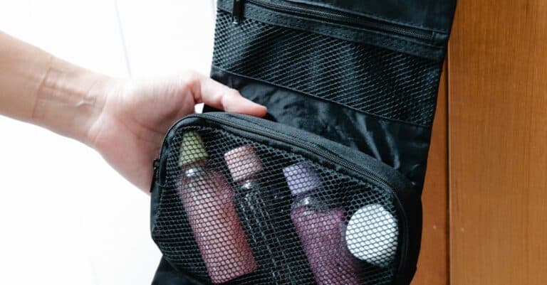 A black toiletry bag with toiletries hanging on a door knob, perfect for travel.